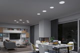 Modernes Wohnzimmer mit weißen LED-Einbaustrahlern in Decke, grauem Sofa und Kamin für gemütliche Beleuchtung