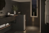 Modernes Badezimmer mit schwarzen Fliesen und warmweißen LED-Lichtleisten für stimmungsvolle Beleuchtung