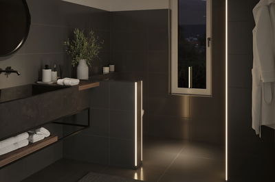 Moderne badkamer met zwarte tegels en warmwitte LED-lichtstrips voor sfeervolle verlichting