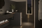 Modern bathroom with black tiles and warm white LED light strips for ambient bathroom lighting