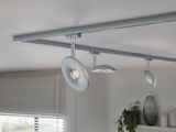 Moderne loftlampe med tre sølvfarvede LED-spotlights på skinnesystem til opholdsrum.