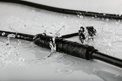 Câble noir étanche avec connecteur sous éclaboussures d'eau, adapté aux connexions électriques extérieures