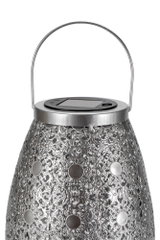 Metal lantern with intricate pattern and solar panel on top for energy-saving outdoor lighting