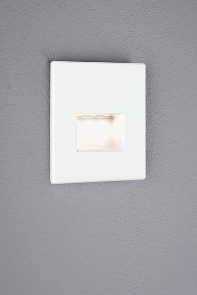 Witte vierkante LED-inbouwwandlamp met warm wit licht op grijze muur