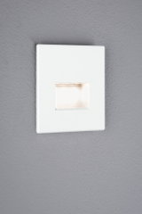 White square LED recessed wall light with warm white illumination on grey wall