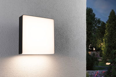 Square outdoor wall light with white acrylic glass and black frame for garden lighting
