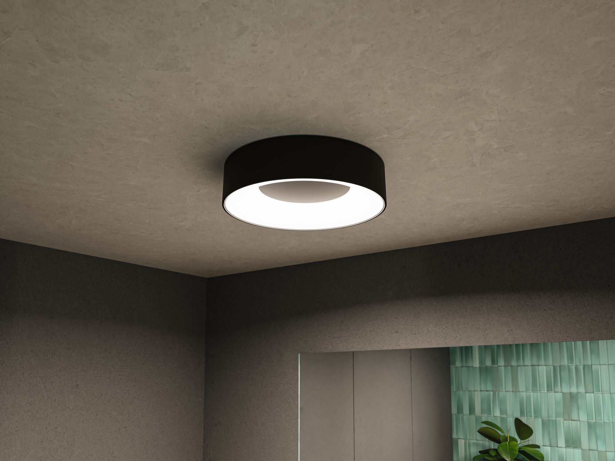 Plafonnier rond noir avec diffuseur blanc dans une pièce moderne aux murs gris et accent carrelé vert.