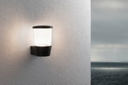 Schwarze Außenwandleuchte mit weißem Glas an weißer Wand, stimmungsvolle Beleuchtung für Terrasse