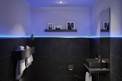 Salle de bain moderne avec céramique noire, éclairage LED en bande et mobilier minimaliste