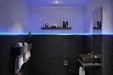 Salle de bain moderne avec céramique noire, éclairage LED en bande et mobilier minimaliste