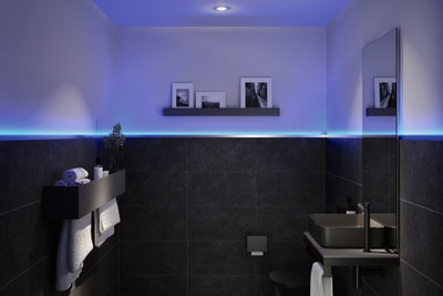 Salle de bain moderne avec céramique noire et éclairage LED bleu en bande sur le mur