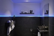 Modern bathroom with black ceramic and blue LED strip lighting along the wall