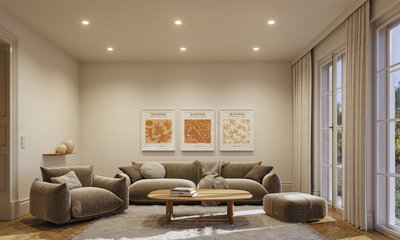 Modernes Wohnzimmer mit beigem Stoffsofa, Sessel, Hocker und Holz-Couchtisch auf hellem Teppich.