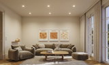 Moderne woonkamer met beige stoffen bank, fauteuil, poef en houten salontafel op licht tapijt.