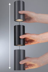 Drei schwarze zylindrische LED-Pendelleuchten aus Metall, die von Händen gehalten werden, mit Höhenverstellfunktion.