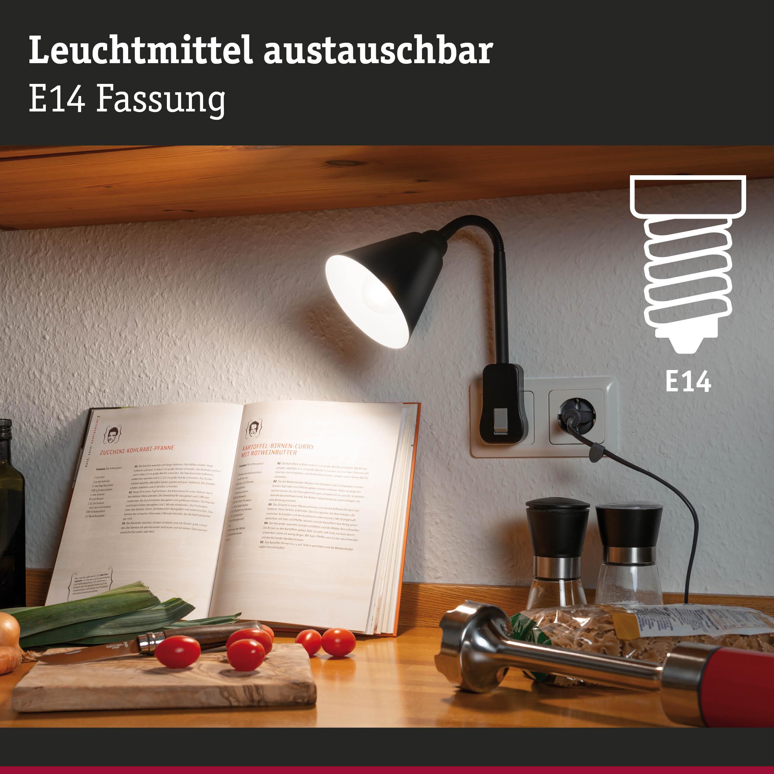 Schwarze E14 Wandleuchte mit flexiblem Arm beleuchtet Kochbuch und Küchenarbeitsfläche mit Tomaten.