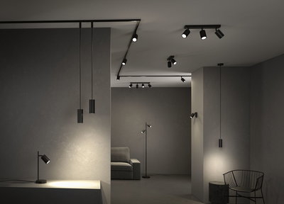 Moderne sorte LED-spotlights og pendellamper i minimalistisk rum med grå vægge og møbler