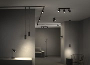 Spots LED noirs modernes et suspensions dans une pièce minimaliste aux murs et meubles gris