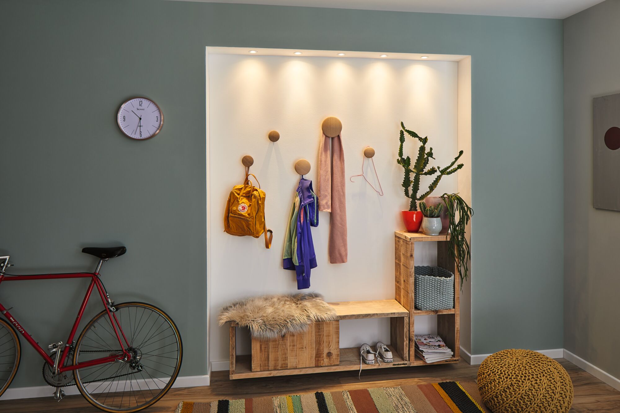 Lyst trægangsmøbel med bænk, knager og LED-spotlys, moderne boligbelysning.