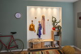 Bright wooden hallway shelf with bench, coat hooks, and LED spotlights, modern home lighting.