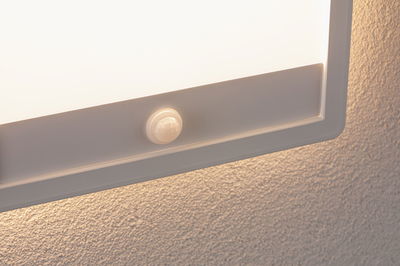 Panneau lumineux LED blanc avec détecteur de mouvement intégré sur mur texturé pour éclairage économique