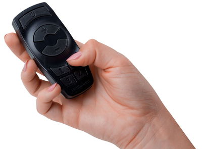Black plastic remote control with buttons for light control held in hand