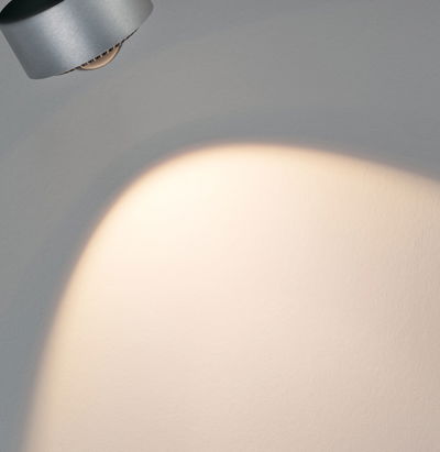Modern silver aluminum wall spotlight with warm white light for accent lighting