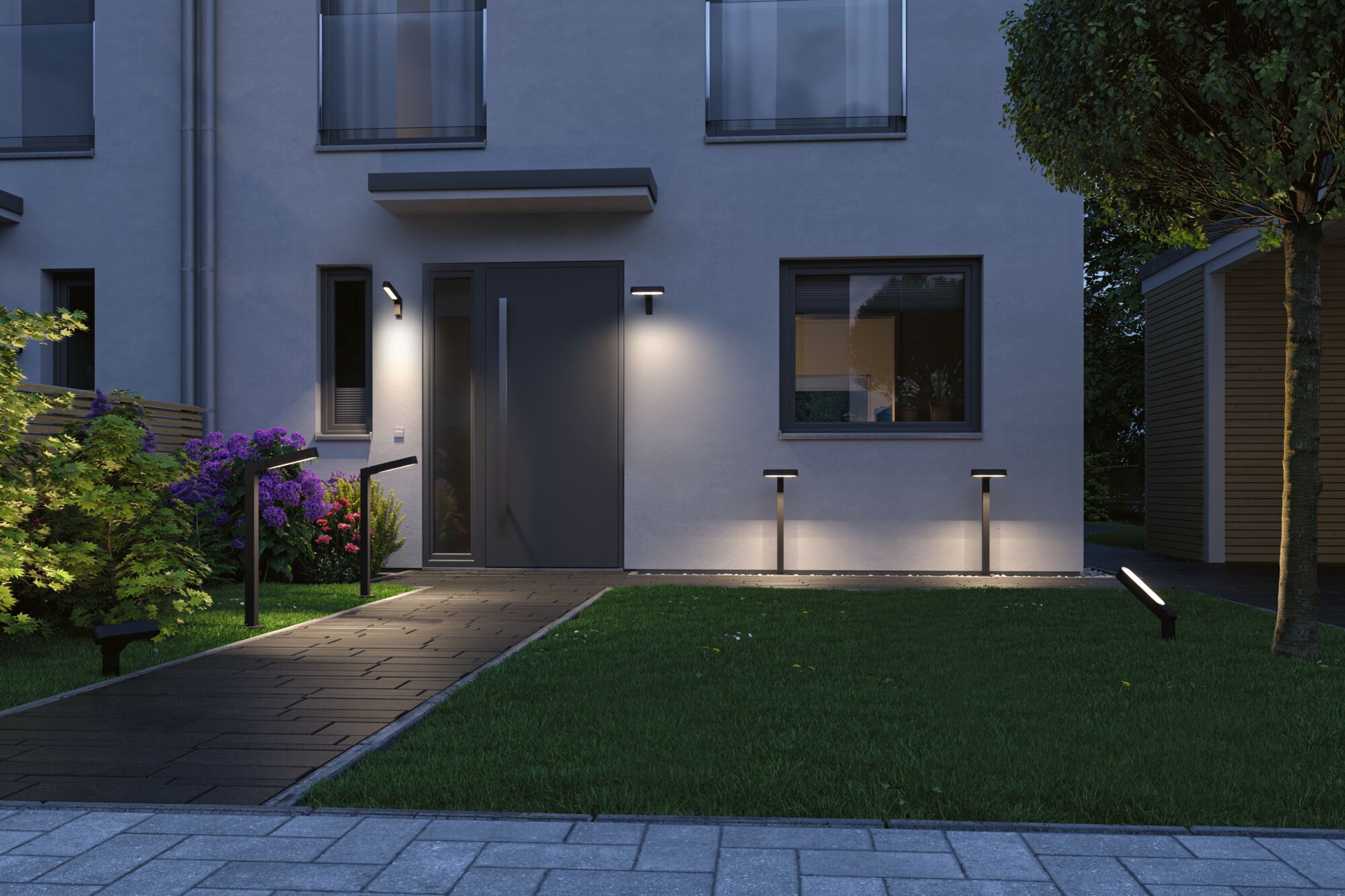 Modern black LED outdoor lights on house wall and garden path illuminate entrance and lawn area.