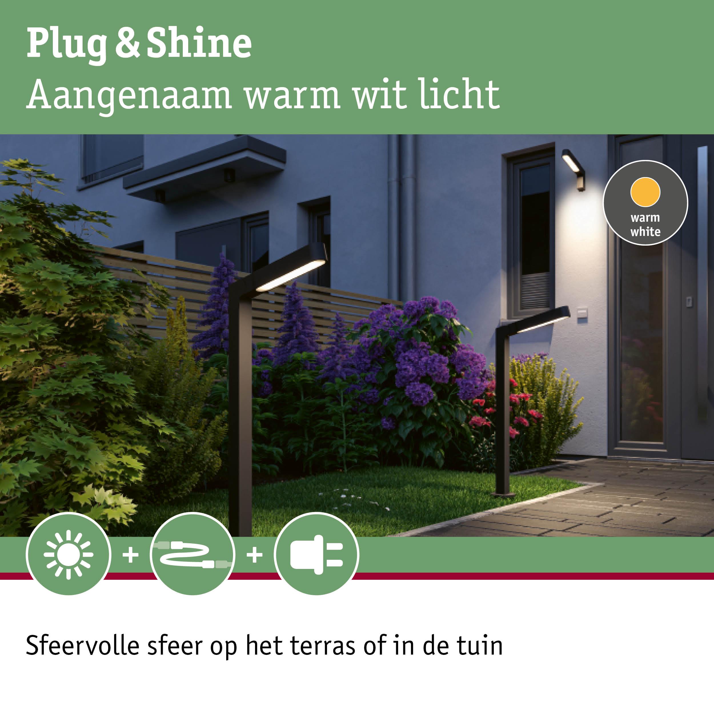 Moderne zwarte buitenlampen met warm wit licht verlichten tuinpad en terras bij schemering
