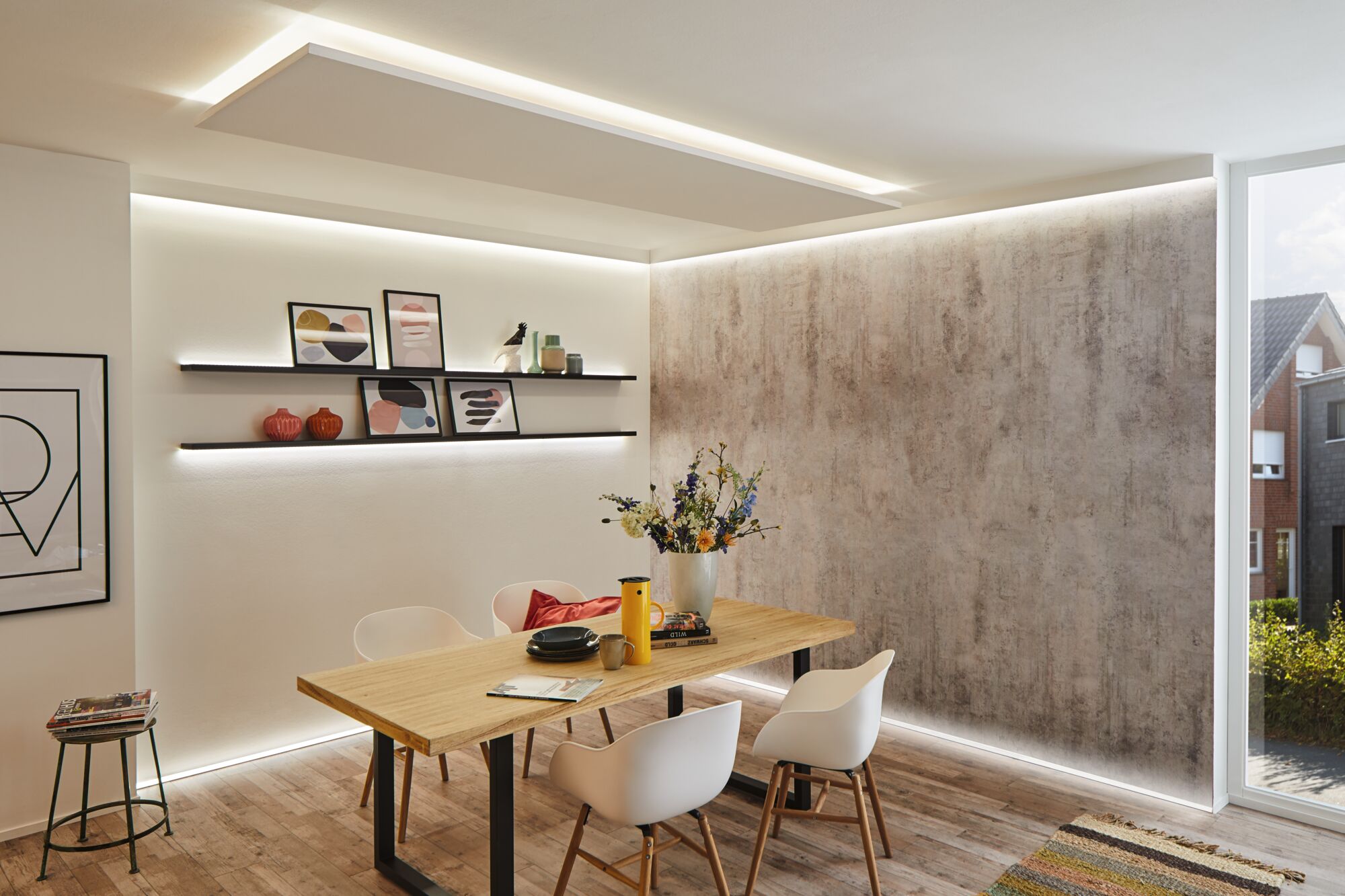 Modern dining room with wooden table, white chairs, and indirect LED lighting on walls and ceiling