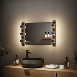 Modernes Badezimmer mit schwarzem Keramik-Waschbecken und warmweißen LED-Wandleuchten links und rechts am Spiegel.