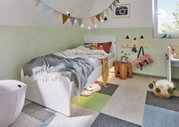 Kinderkamer met wit houten bed, kleurrijke vlaggenlijn en zacht tapijt met gekleurde vierkanten