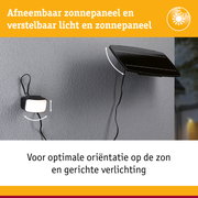 Afneembaar zwart zonnepaneel met verstelbaar licht aan grijze muur voor buitenverlichting