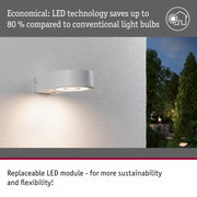 Modern grey metal LED outdoor wall light with energy-saving illumination mounted on house wall