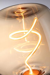 Nahaufnahme einer warmweißen LED-Glühbirne mit geschwungenem Leuchtfaden und bernsteinfarbenem Glas