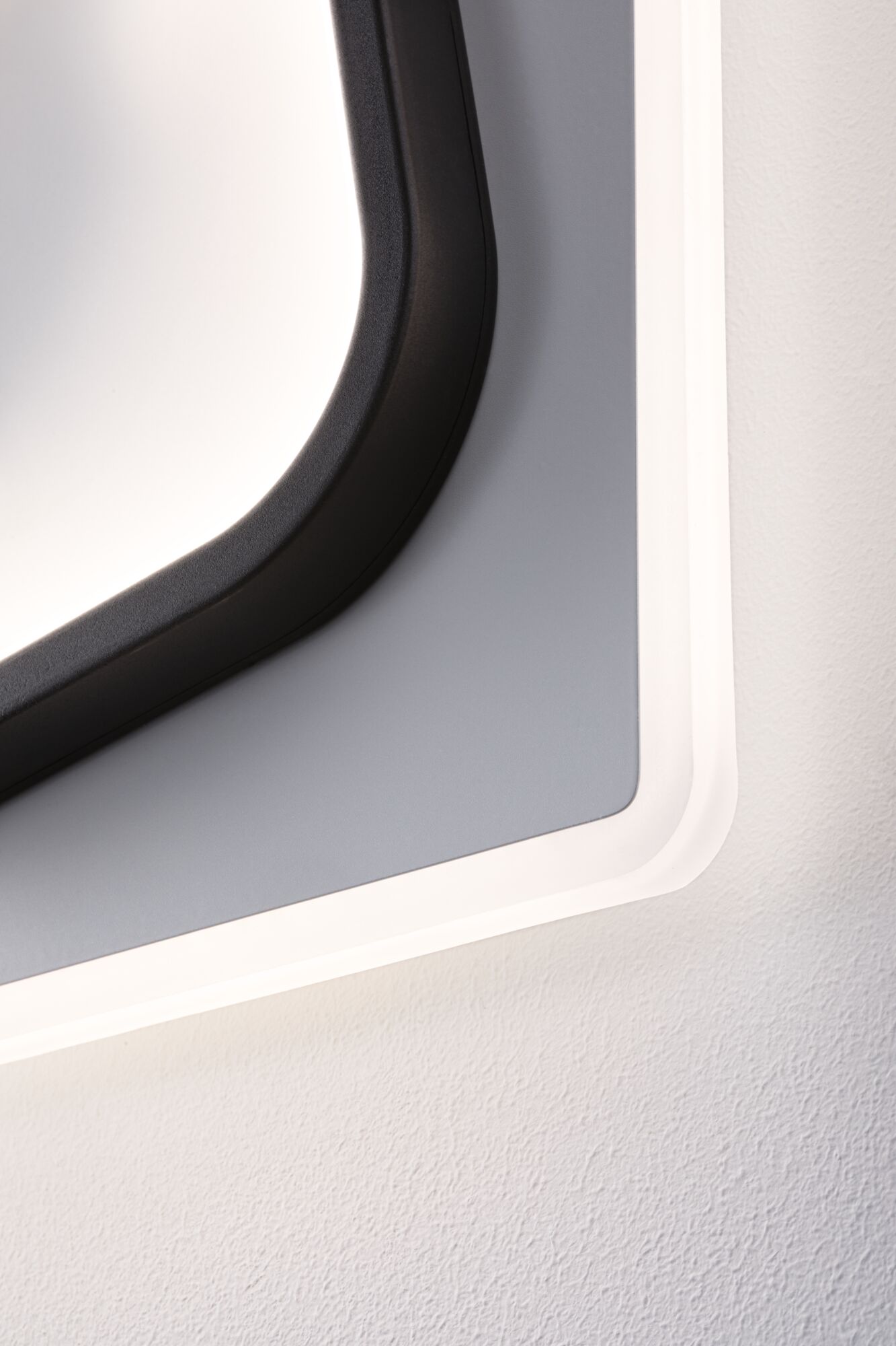 Close-up of modern LED wall light with black frame and white illumination for indoor use.