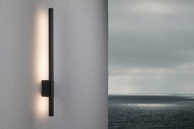 Black metal LED wall light with indirect warm white illumination for modern outdoor spaces.
