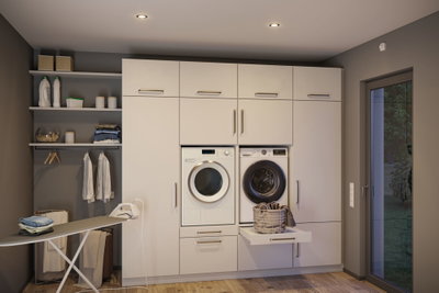 Modern white built-in laundry room with washing machine, dryer, and integrated ironing board in light wood space.