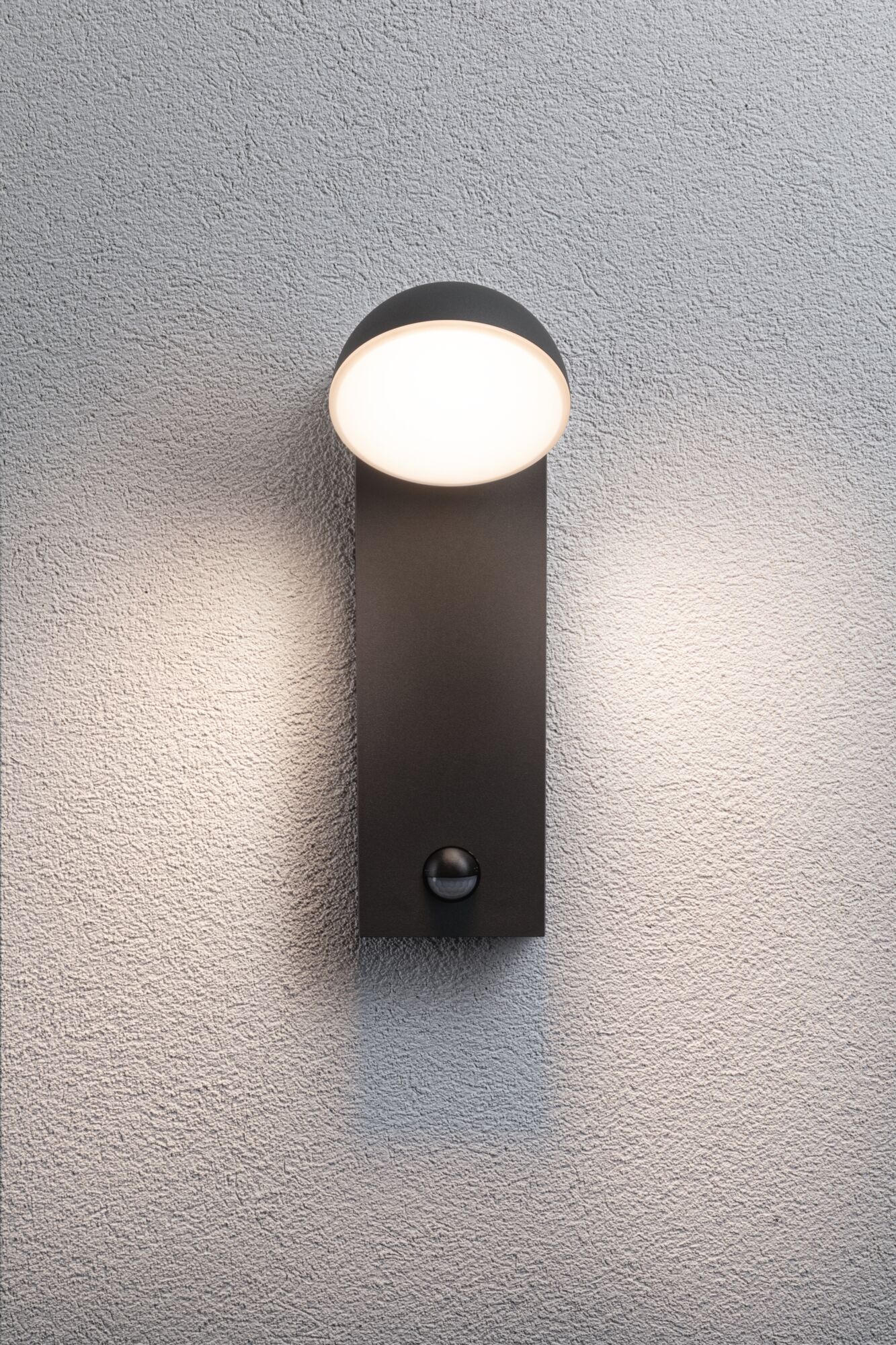 Moderne sort metal væglampe med rund hvid diffuser og bevægelsessensor til udendørsbelysning