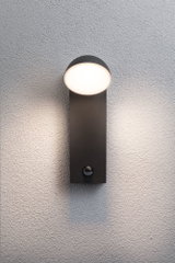 Moderne sort metal væglampe med rund hvid diffuser og bevægelsessensor til udendørsbelysning