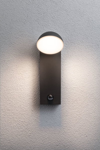 Moderne sort metal væglampe med rund hvid diffuser og bevægelsessensor til udendørsbelysning