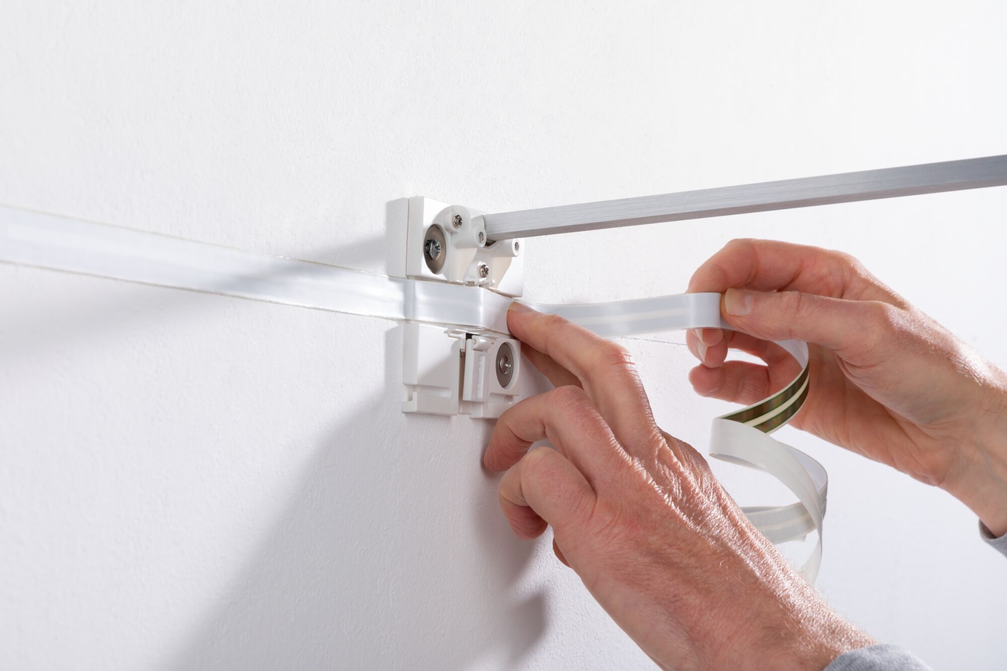 Montage van witte LED-kunstlicht met aluminium beugel aan witte muur voor wandverlichting