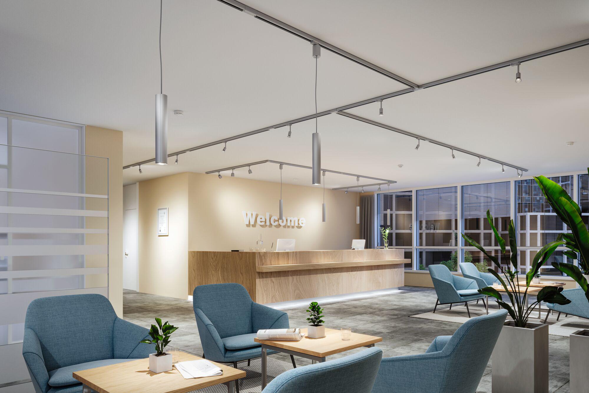 Modern office with silver aluminium LED track spotlights and pendant lights on white ceiling