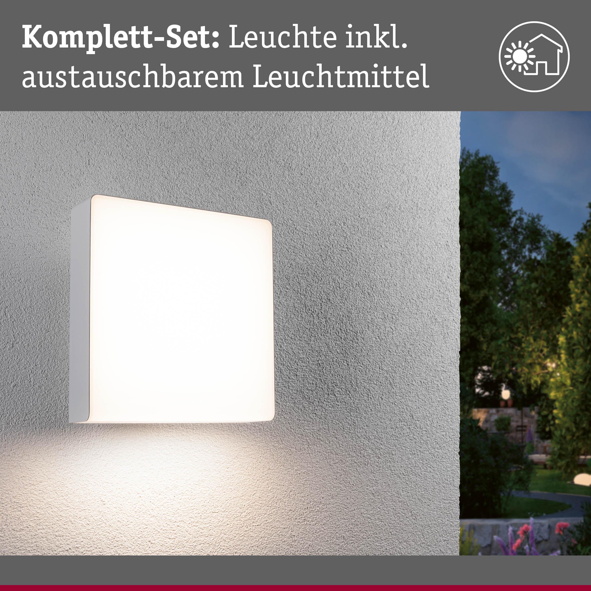 Weißes quadratisches Außenwandleuchte mit austauschbarem Leuchtmittel an grauer Wand beleuchtet Gartenweg