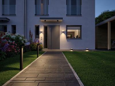 Moderner Außenweg mit schwarzen LED-Wegeleuchten und Hausfassadenbeleuchtung in warmweißem Licht