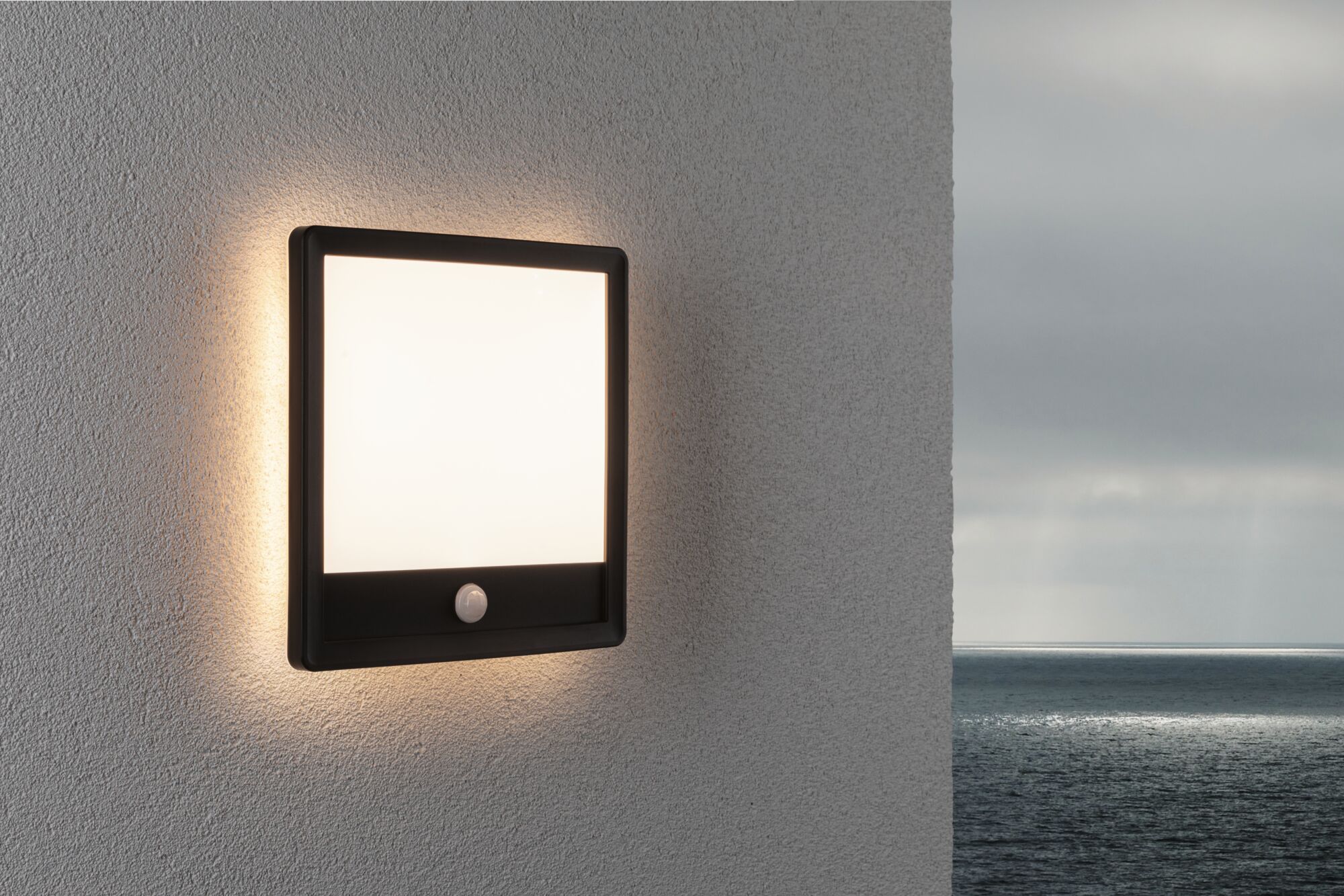 Applique murale extérieure carrée noire avec détecteur de mouvement et lumière blanche chaude sur mur gris