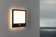 Applique murale extérieure carrée noire avec détecteur de mouvement et lumière blanche chaude sur mur gris