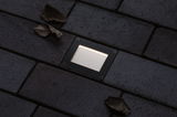 Rectangular black LED recessed floor light with warm white illumination on dark pavement.