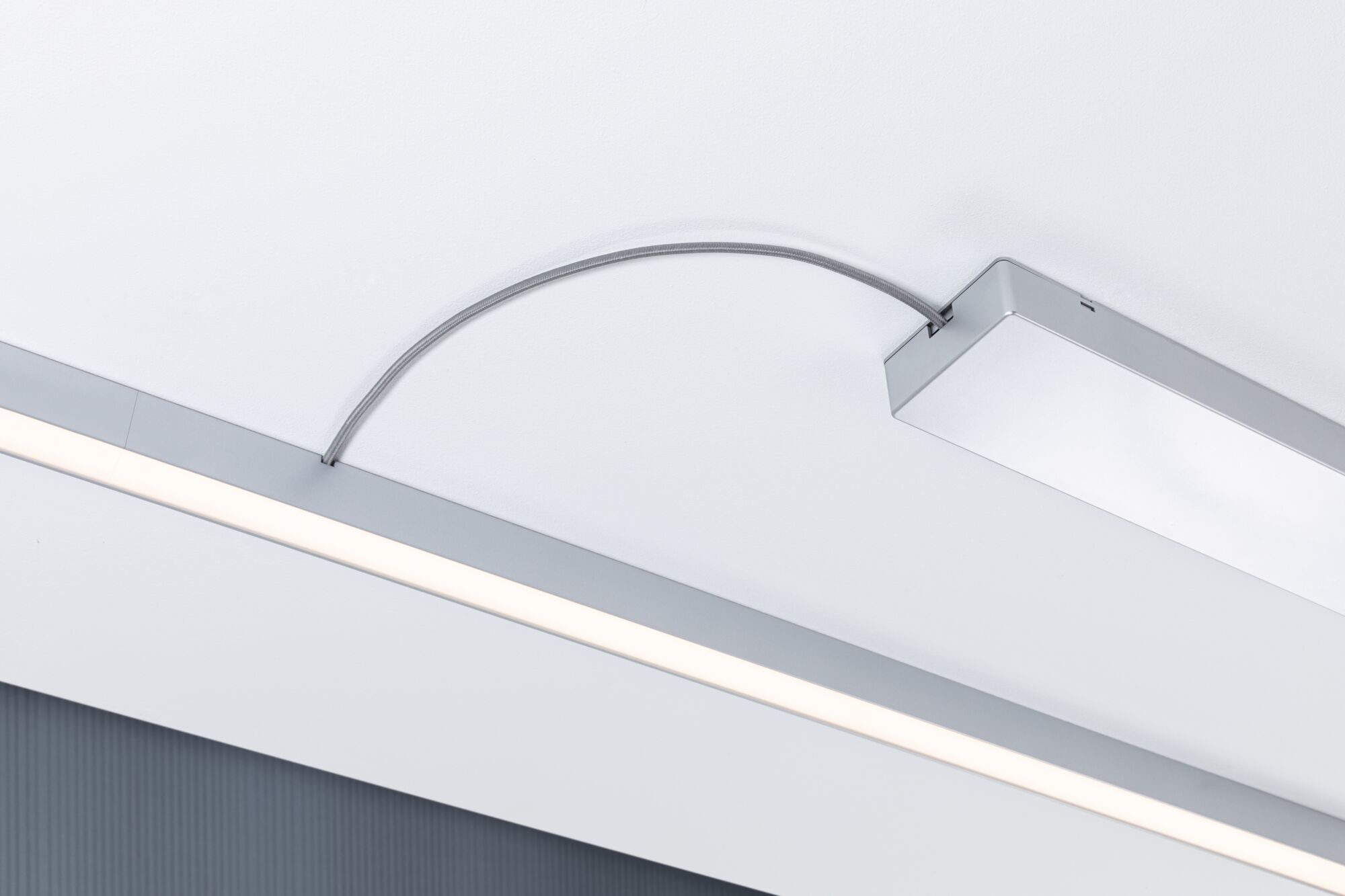 Modern LED ceiling light with silver aluminum housing and flexible connection cable for living spaces.