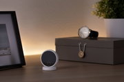 Small round white LED night light with touch switch on wooden table near watch and storage box